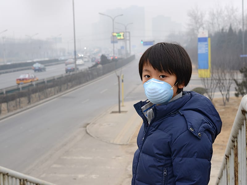 Child with anti-smog mask