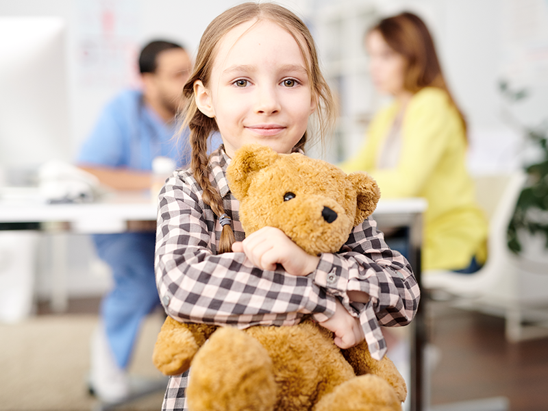 Young girl hugging teddy bear
