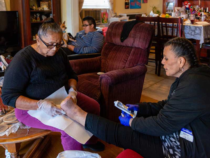 Patricia Zamora’s grandmother helps clean her wound.