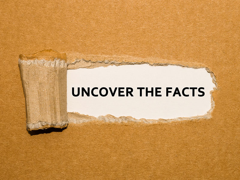 Uncover the facts text on brown paper background