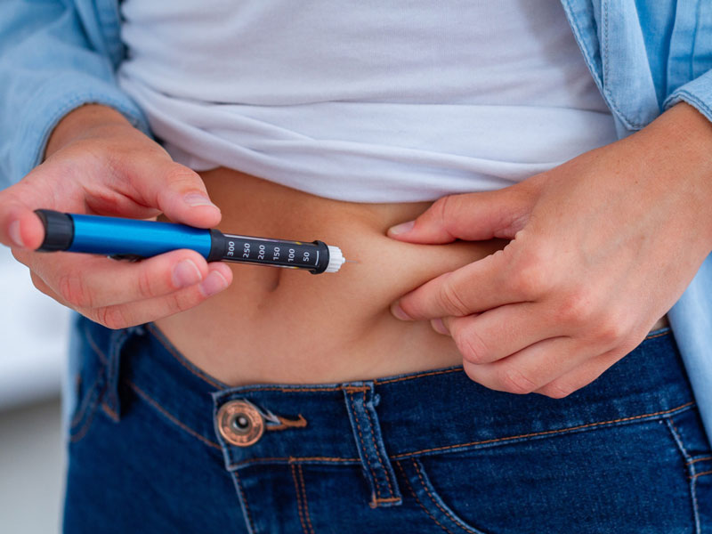 A person with diabetes makes an insulin injection with insulin pen at home