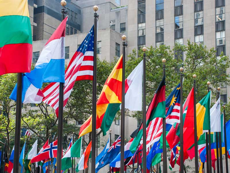 Rows of flags of all nations next to UN in New York