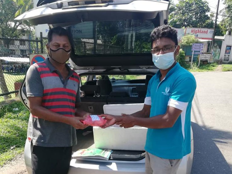 Vikasith and Gemunu loading car with supplies